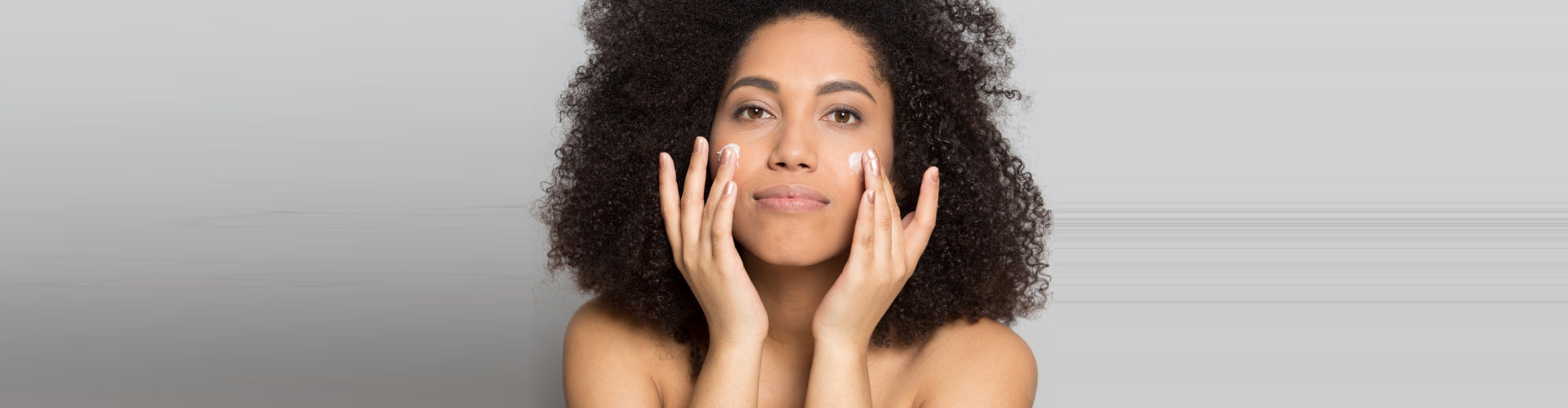 woman applying cream to her face